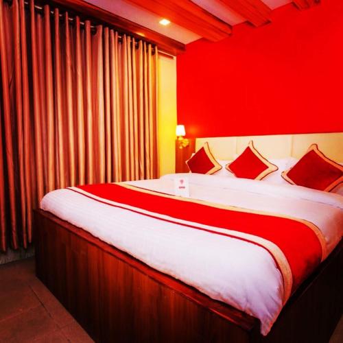 a bedroom with a large bed with red walls at Hotel Shraddha Palace in Kathmandu