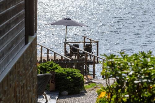 a table with an umbrella next to the water at Argo Trakai in Trakai