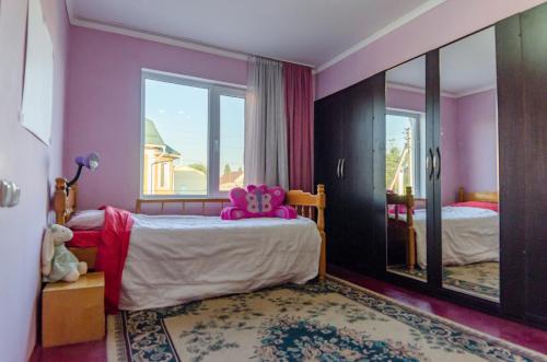 a bedroom with a bed with a teddy bear on it at ilim-mahabat in Bishkek
