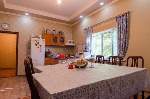 a kitchen with a table and a kitchen with a refrigerator at ilim-mahabat in Bishkek