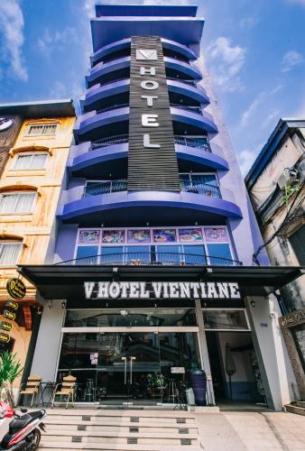 a tall blue building with a hotel sign on it at V Hotel Vientiane in Vientiane