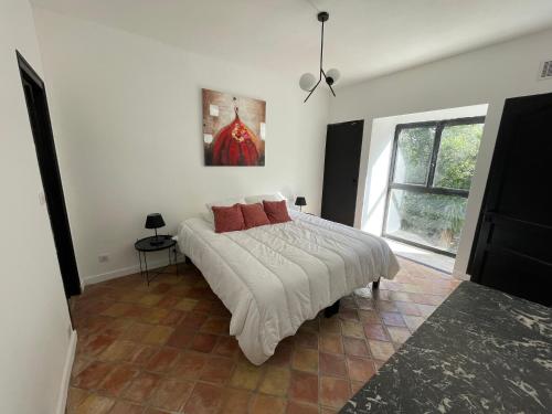 una camera da letto con un letto e un dipinto sul muro di Villa provençale, 8 personnes, très grande piscine et jardin, au calme, salle de fitness et espace coworking a Opio