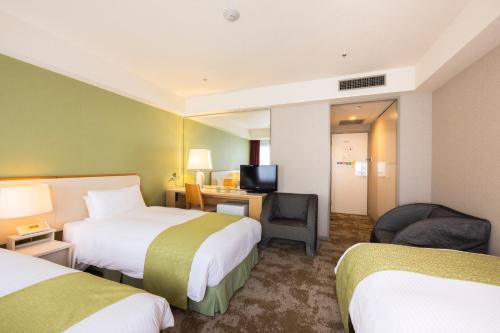 a hotel room with two beds and a desk at Shinjuku Washington Hotel Annex in Tokyo