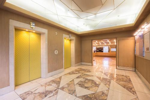 an empty lobby with yellow walls and a tile floor at Shinjuku Washington Hotel Annex in Tokyo