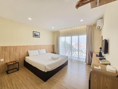 a hotel room with a bed and a television at Douangchan Plaza Hotel in Vientiane