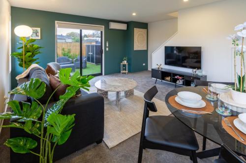 a living room with a black couch and a table at Serene Living 2 bed with Carpark in Christchurch