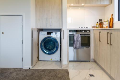 a kitchen with a washing machine and a dishwasher at Serene Living 2 bed with Carpark in Christchurch