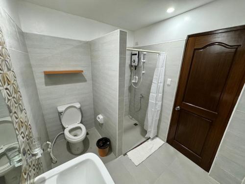 a bathroom with a toilet and a shower and a sink at Marina Village in Moalboal