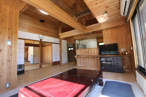 a large room with wooden walls and wooden flooring at 白子ハウス in Goi