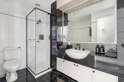 een badkamer met een toilet, een wastafel en een douche bij Style and Convenience on Little Bourke in Melbourne
