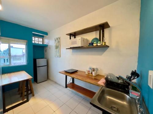 Suites Brisa Marina - Playa Regatas y Malecón في فيراكروز: مطبخ صغير مع حوض ومكتب