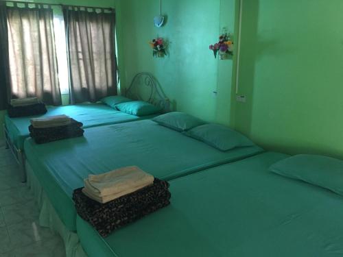 two twin beds in a room with blue walls at Sin U Rai Resort in Ko Larn