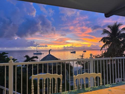 a view of a sunset from a balcony with chairs at Meri Lodge Huahine « ROOM OF MARTA » in Fare