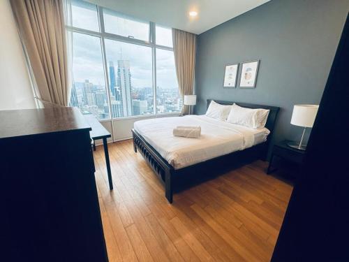 ein Schlafzimmer mit einem Bett und einem großen Fenster in der Unterkunft Vortex Suites KLCC by Nadia Guesthouse Kuala Lumpur in Kuala Lumpur