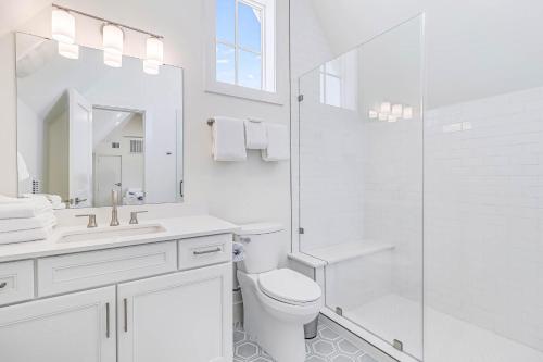 Un baño blanco con inodoro y ducha. en Sunrise Beach Bungalow, en Port Aransas