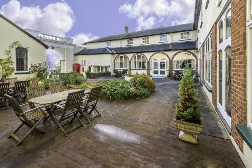 an outdoor patio with a wooden table and chairs at Lord Haldon Country Hotel, Sure Hotel Collection by Best Western in Exeter