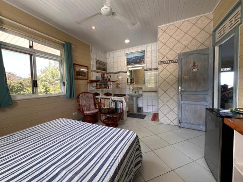 ein Schlafzimmer mit einem Bett und einem Waschbecken in einem Zimmer in der Unterkunft Meri Lodge Huahine « ROOM OF MARTA » in Fare