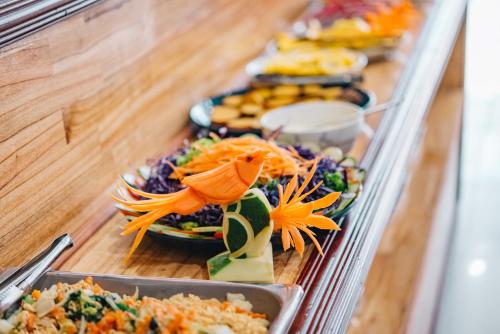 a buffet line with plates of food on display at V Hotel Vientiane in Vientiane