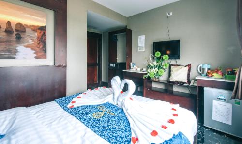 a bedroom with a bed with a towel on it at V Hotel Vientiane in Vientiane
