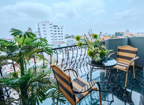 a balcony with two chairs and a table with plants at V Hotel Vientiane in Vientiane