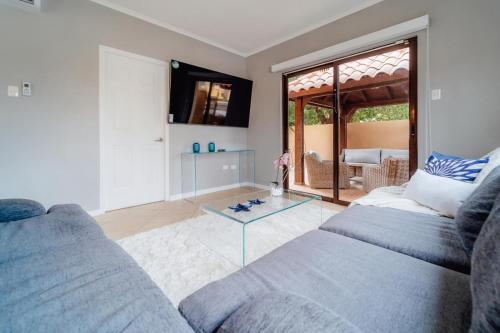 ein Wohnzimmer mit einem Sofa und einem Glastisch in der Unterkunft The best house in gold coast 4 bedrooms in Palm-Eagle Beach