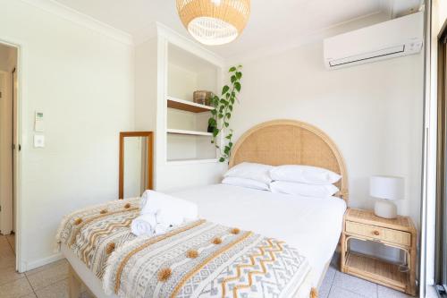 a bedroom with a bed with white sheets and pillows at Surfers Rest in Byron Bay