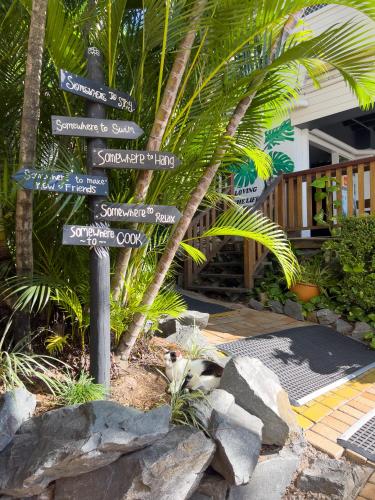a street sign with many different signs on it at Somewhere To Stay Backpackers in Brisbane