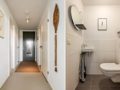 a bathroom with a toilet and a sink and a mirror at Stylish Countryside Home in Wissenkerke