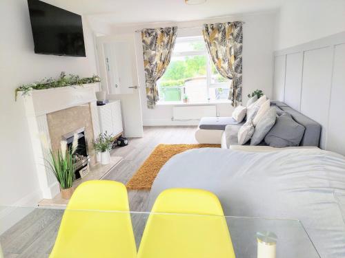 a living room with a bed and yellow chairs at 'Serenity in Somerset' , Scenic Views across Dorset , Half a mile from Devon & Close to the Jurassic Coast without the Hustle & Bustle in Chardstock