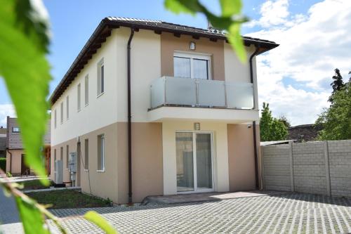 a house with a balcony on top of it at Silentium Premium Apartman Sárvár in Sárvár