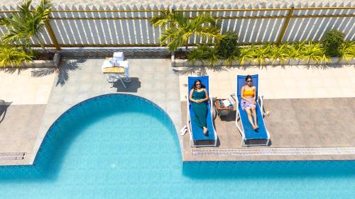 an overhead view of a swimming pool with two women in dresses at Daksh Eden Greenz -A Luxury Resort in Sasan Gir in Sasan Gir