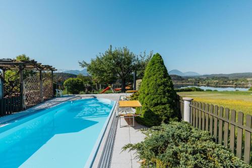 a swimming pool with a fence and trees at Ferienwohnungen Martha in Obersammelsdorf