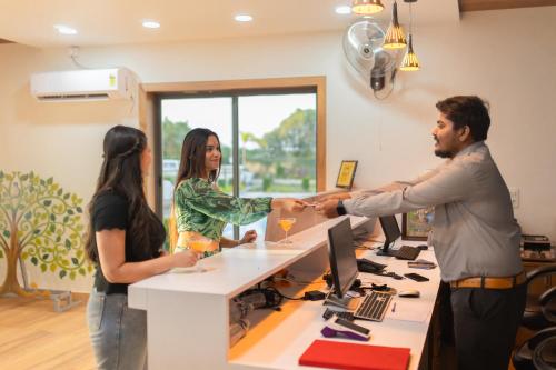 a group of people standing around a desk in an office at Daksh Eden Greenz -A Luxury Resort in Sasan Gir in Sasan Gir