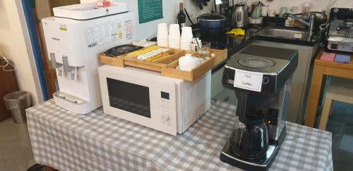a kitchen counter with a coffee maker on a table at Appletree Hotel Pohang in Pohang