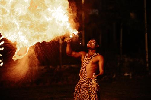 a man is holding up a piece of smoke at Daksh Eden Greenz -A Luxury Resort in Sasan Gir in Sasan Gir