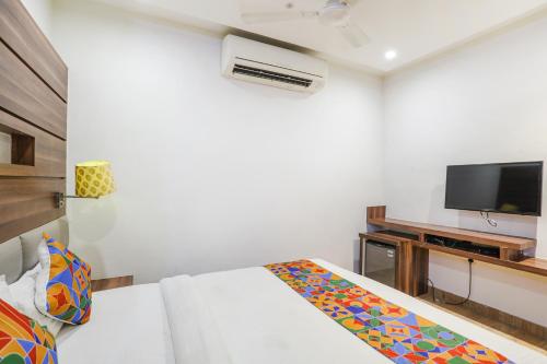 1 dormitorio blanco con 1 cama y TV en FabHotel Prime Mahendra, en Raipur