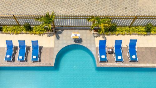 an overhead view of a swimming pool with blue chairs at Daksh Eden Greenz -A Luxury Resort in Sasan Gir in Sasan Gir