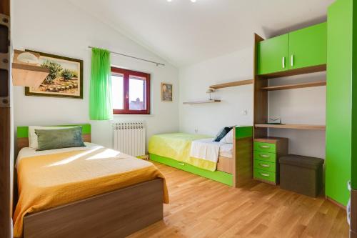 Un dormitorio con dos camas y armarios verdes. en Apartman Dina, en Zadar