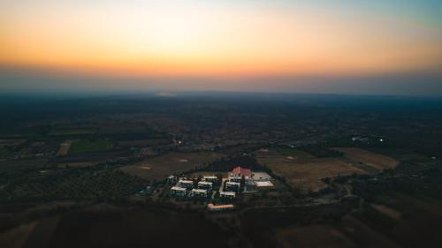 an aerial view of a house with the sunset in the background at Daksh Eden Greenz -A Luxury Resort in Sasan Gir in Sasan Gir