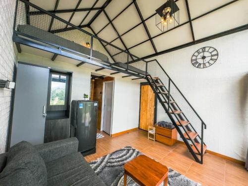 ein Wohnzimmer mit einem Sofa und einer Treppe in der Unterkunft Alam Kita Glamping & Plantation in Munduk