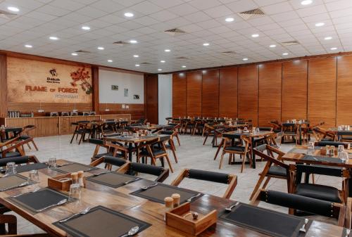 a dining room with wooden tables and chairs at Daksh Eden Greenz -A Luxury Resort in Sasan Gir in Sasan Gir