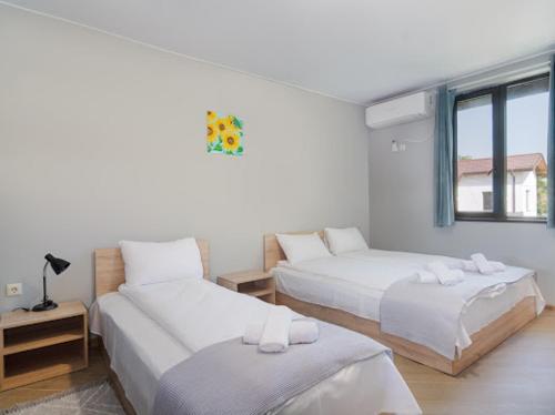 Cette chambre blanche dispose de deux lits et d'une fenêtre. dans l'établissement Къща "Конакъ", à Kyustendil
