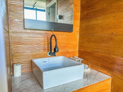 a bathroom with a white sink and a mirror at Alam Kita Glamping & Plantation in Munduk