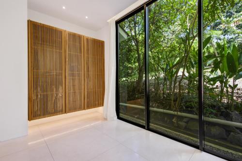 a room with a large window and a view of the forest at New 3 BR Jungle Villa in gated community in Blahbatu