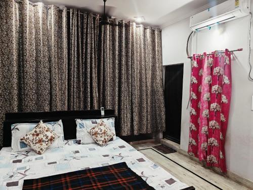1 dormitorio con 1 cama y algunas cortinas en Lata Home Stay, en Haridwar