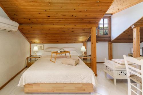 um quarto com uma cama e um tecto de madeira em Villa Sevasti Vintage Loft, Panel Hospitality Homes & Villas em Platamon