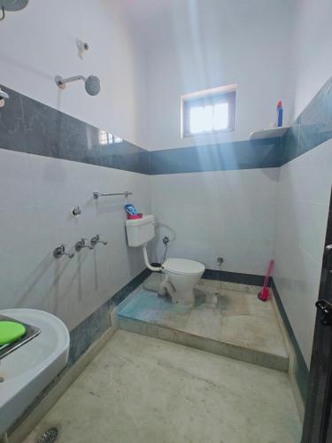 Un baño con inodoro, ducha y lavabo. en Lata Home Stay, en Haridwar