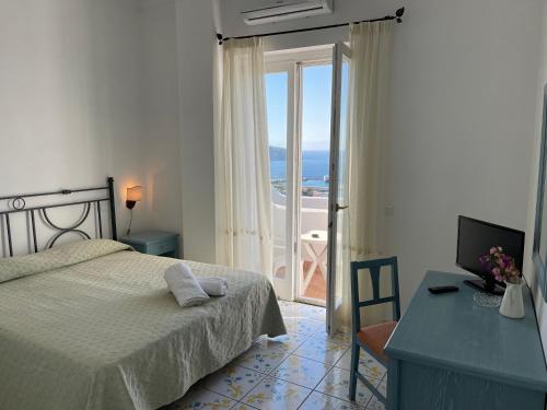 una camera con letto, scrivania e finestra di Hotel Residence - Parco Mare Monte a Ischia
