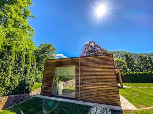 a small house in a garden with the sun overhead at Luxusvilla Österreich in Scheibbs