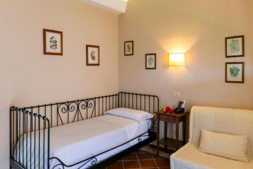 a small bedroom with two beds and a chair at Ghiaccio Bosco in Capalbio